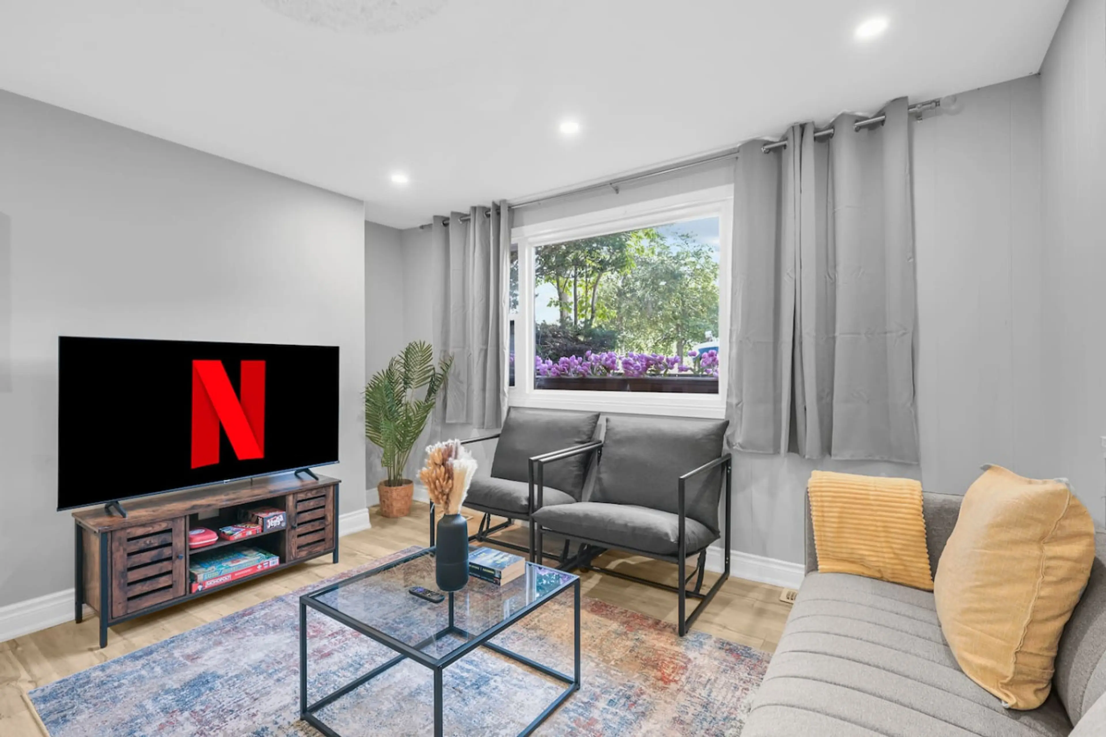 Bright, modern living area with a large smart TV ready for your binge-watching needs. Relax in style and enjoy natural light in this cozy space. Perfect for unwinding after a day of exploring.