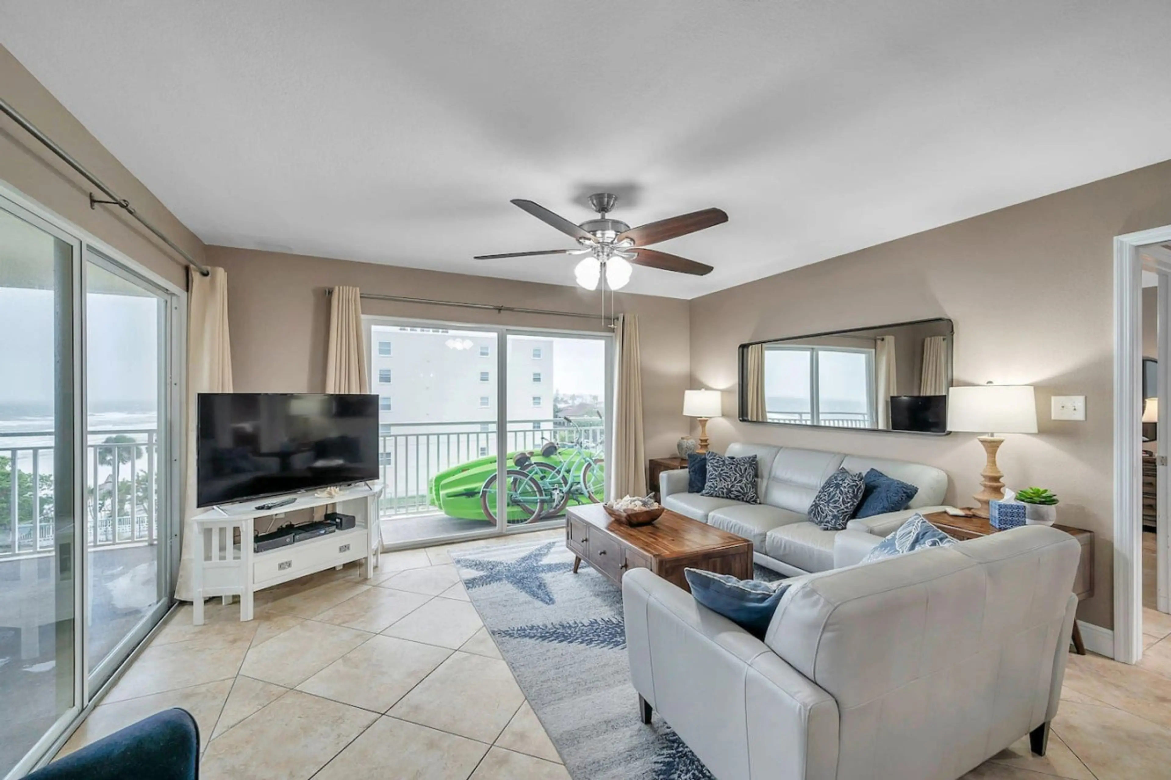 Bright open living area w/ comfy seating, TV, & easy flow to the balcony for indoor-outdoor relaxing.