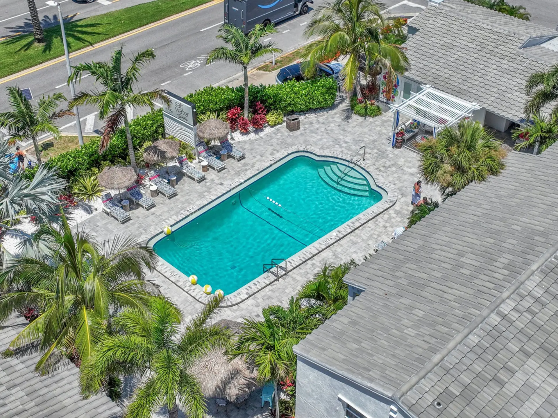 Aerial view of the sparkling pool oasis set among lush landscaping and sunlit lounging areas