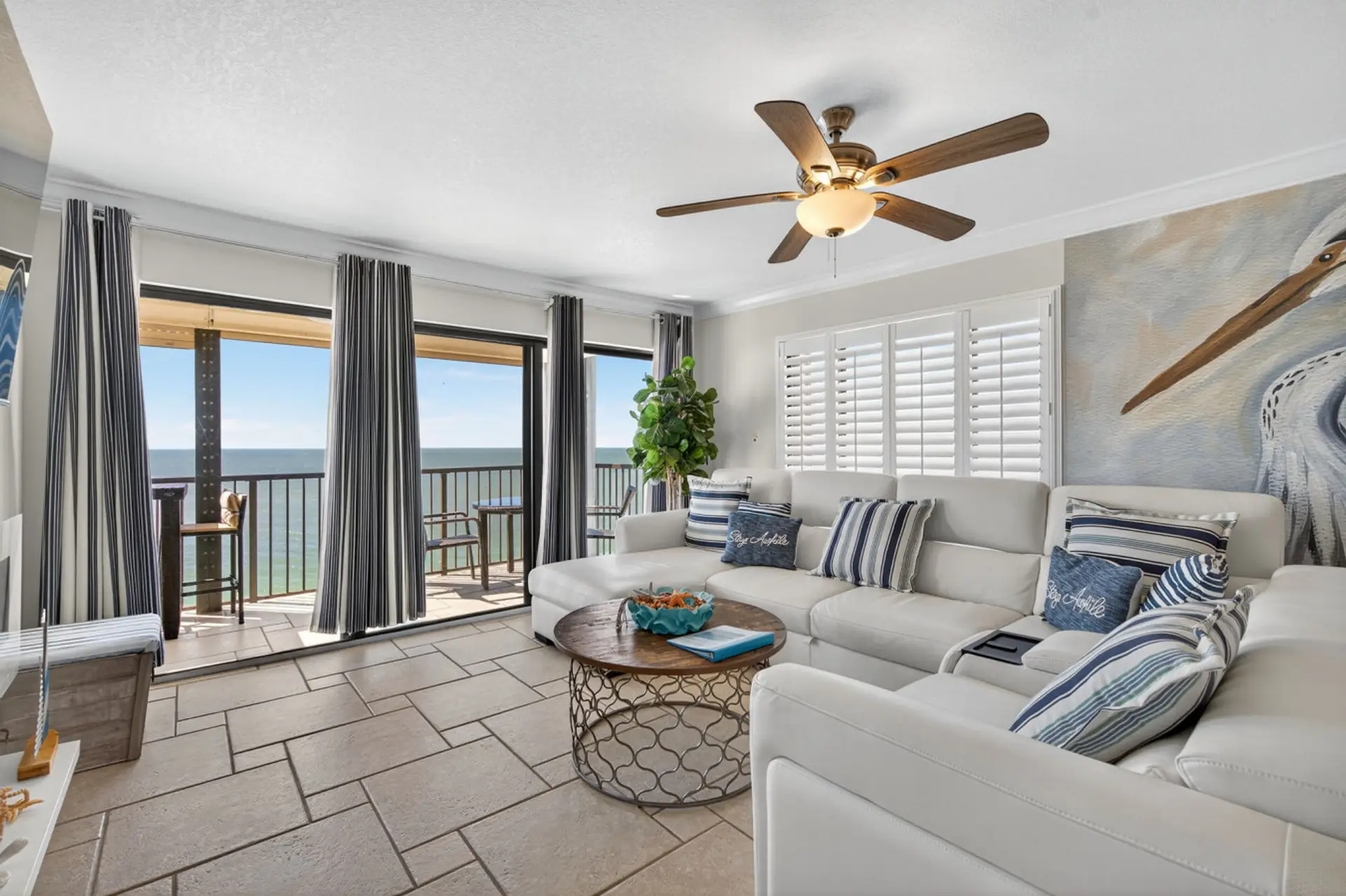 Bright living area w/ comfy seating, coastal decor & large windows framing the water.