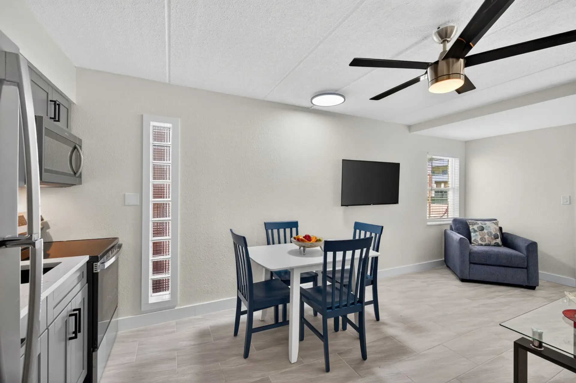 Open living & dining area w/ high ceilings, ceiling fan, and easy flow for gathering or meals.