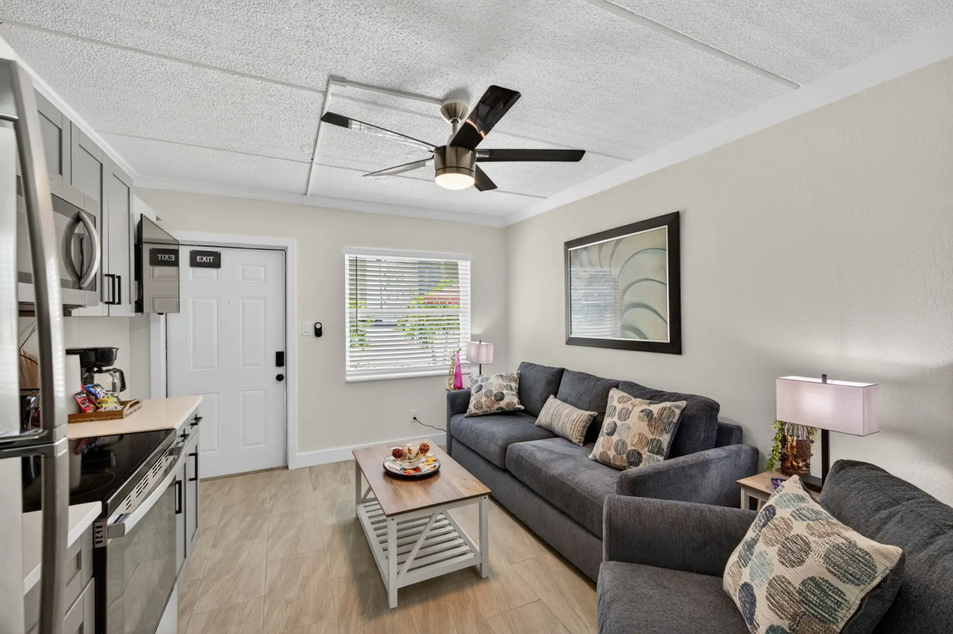 Bright living room w/ comfy seating, ceiling fan & TV—perfect for relaxing after a day out