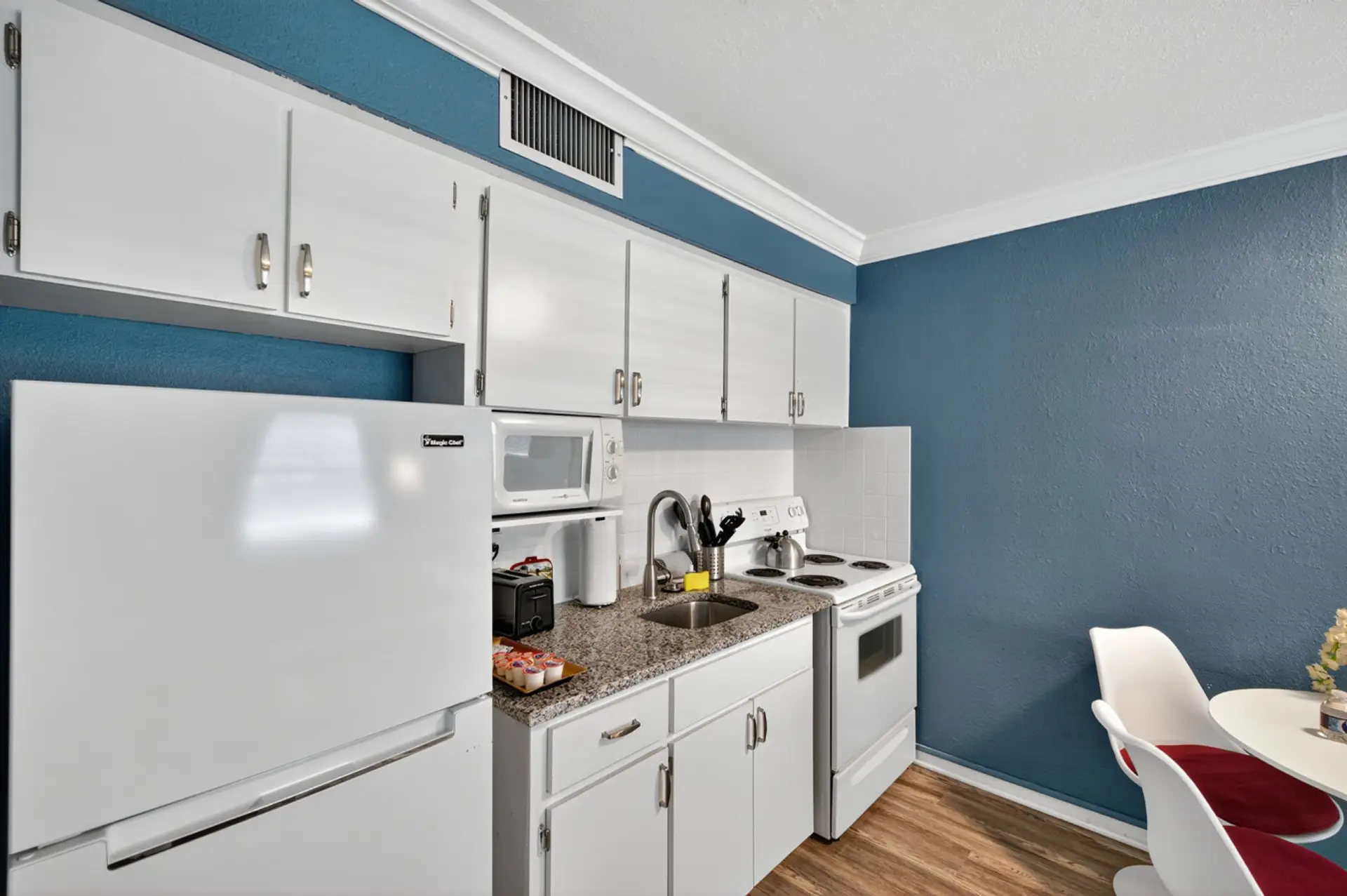 Clean, modern kitchen w/ white cabinetry & everything you need for easy home-cooked meals.