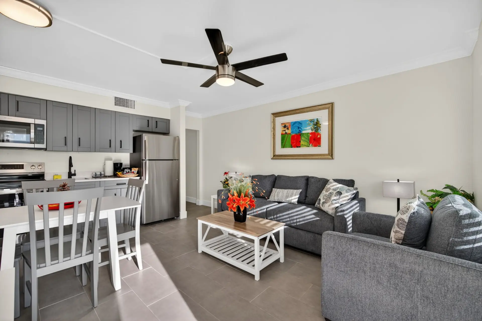 Bright open living area w/ comfy seating, ceiling fan & easy flow into the dining space.