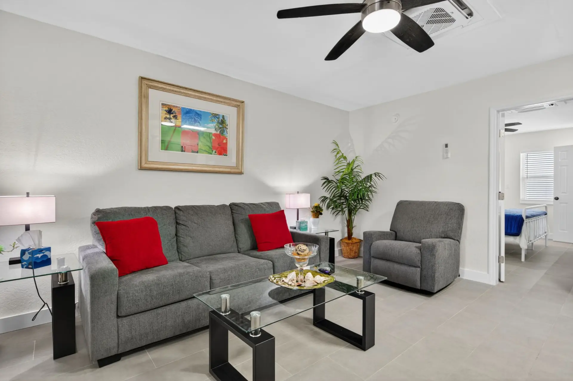 Inviting living room w/ comfy seating, pops of red & a cozy layout for unwinding.