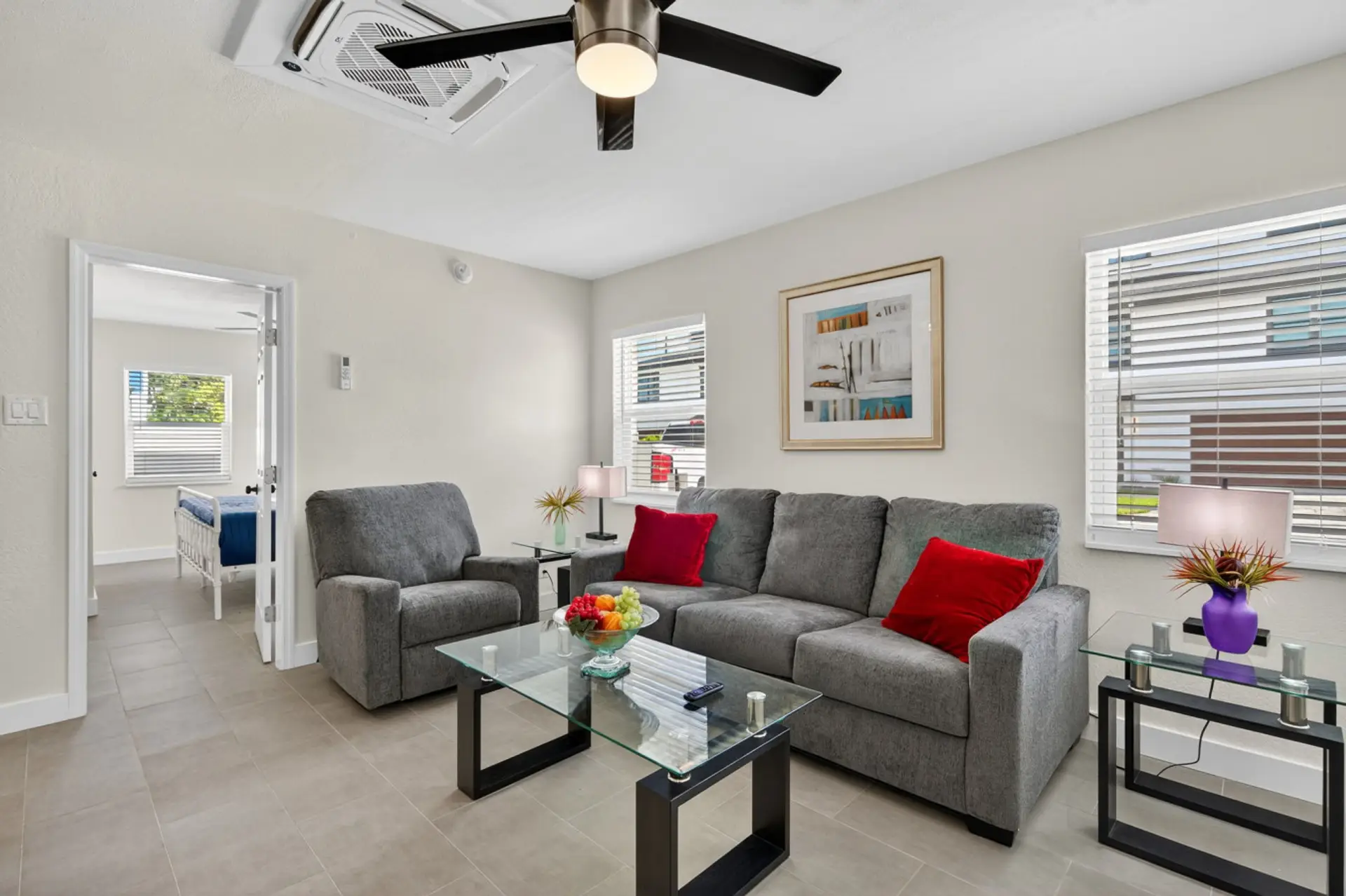 Bright living room w/ comfy seating, pops of color, & an easy flow into the dining area.