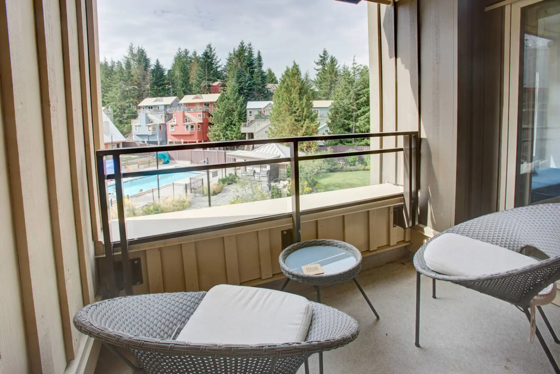 Outdoor seating area with view of the pool, hot tub and BBQ patio area in courtyard