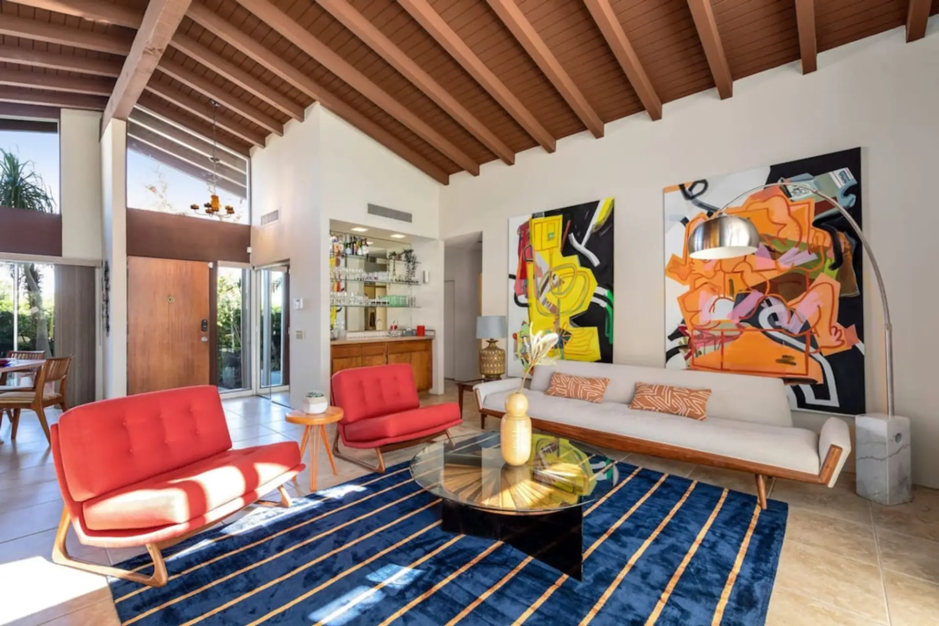 The living room is stylishly decorated with original artwork and midcentury modern furniture