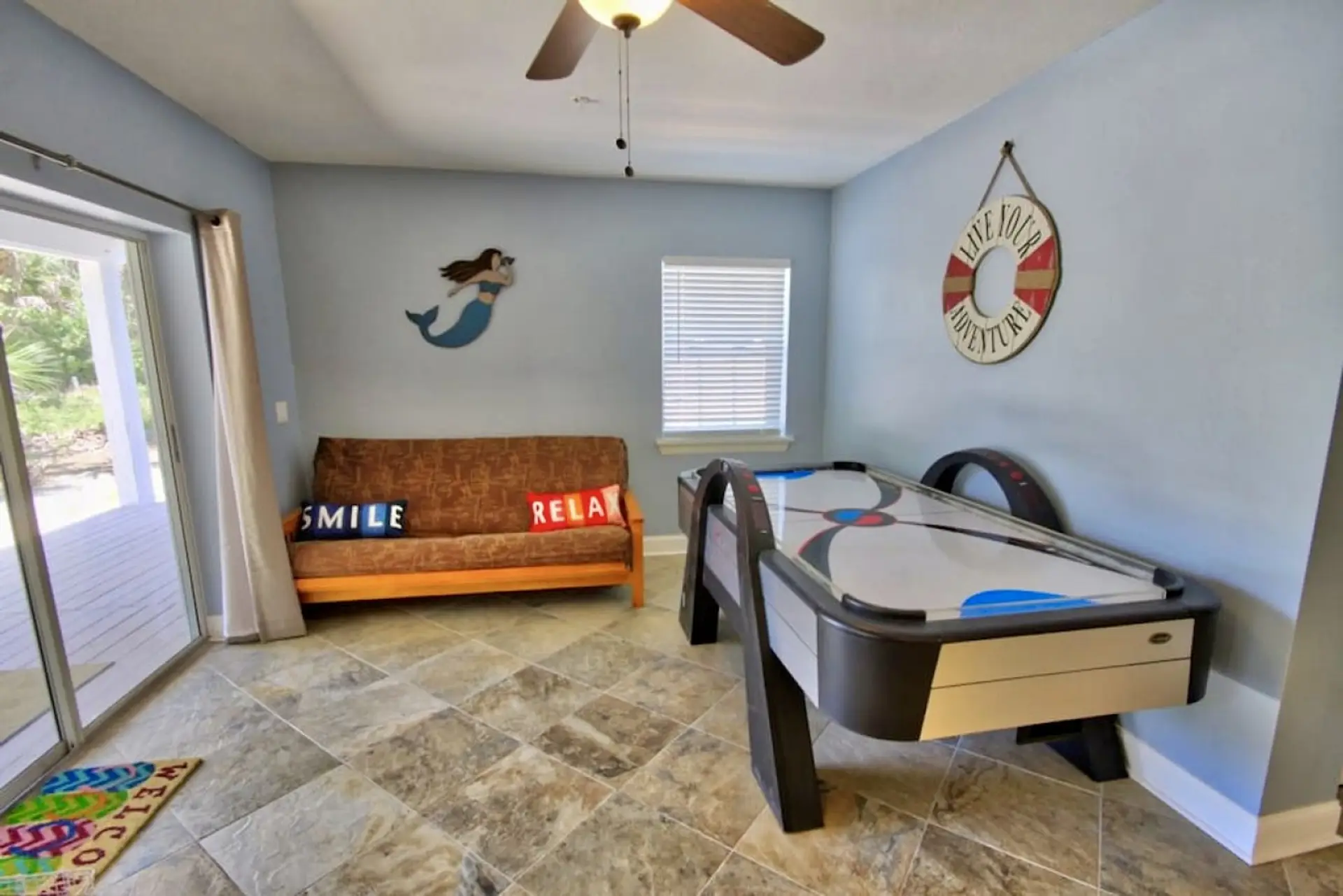 Fun for everyone! The lower-level game room includes air hockey, comfy seating, and cheerful island décor.