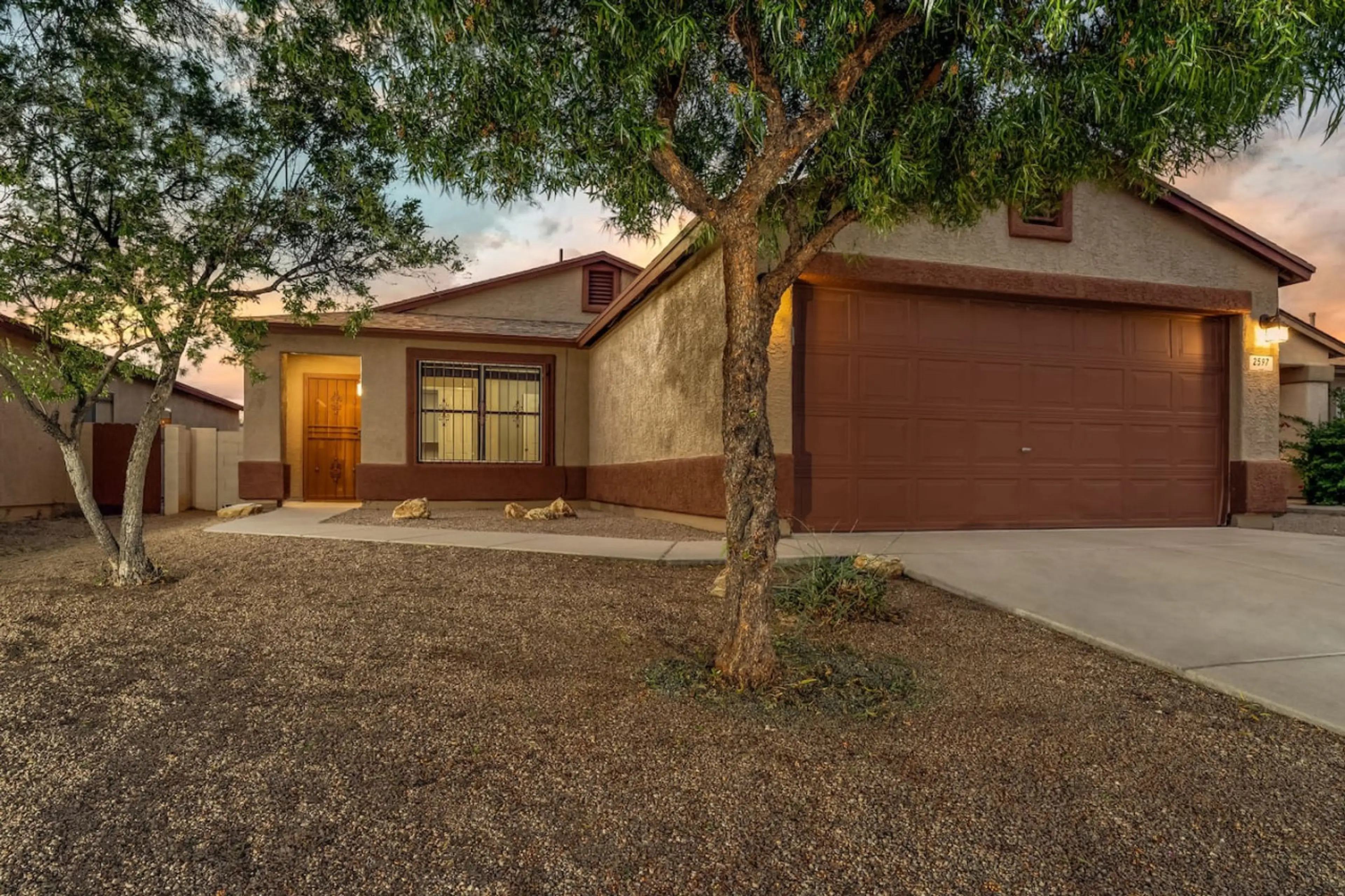 Front view of home, 4 bedroom, 2 bath, 2-car garage, covered back patio with seating, grill, and fire pit