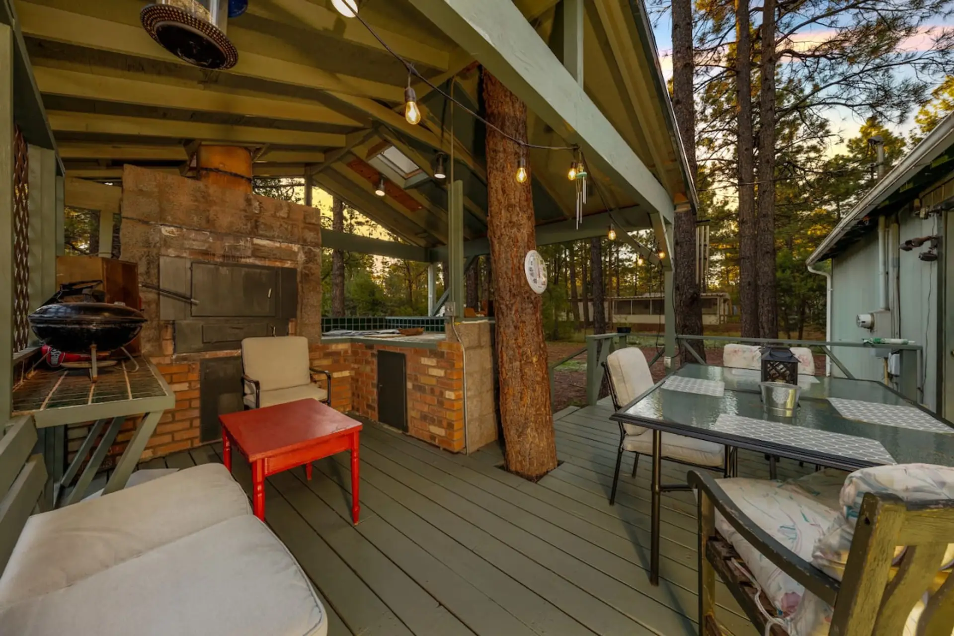 Back patio with outdoor kitchen, wood-burning pizza oven (wood not provided), grill, table, and plenty of seating