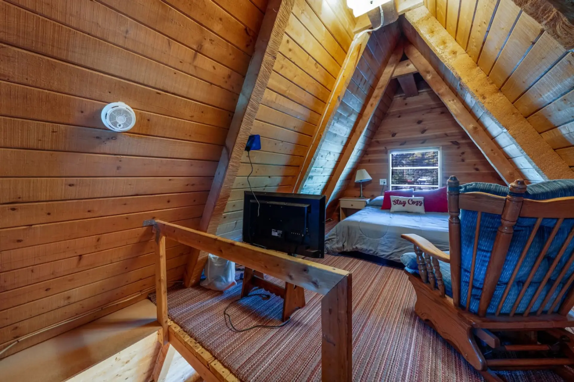Upstairs A-frame loft with double bed, TV, and DVD player