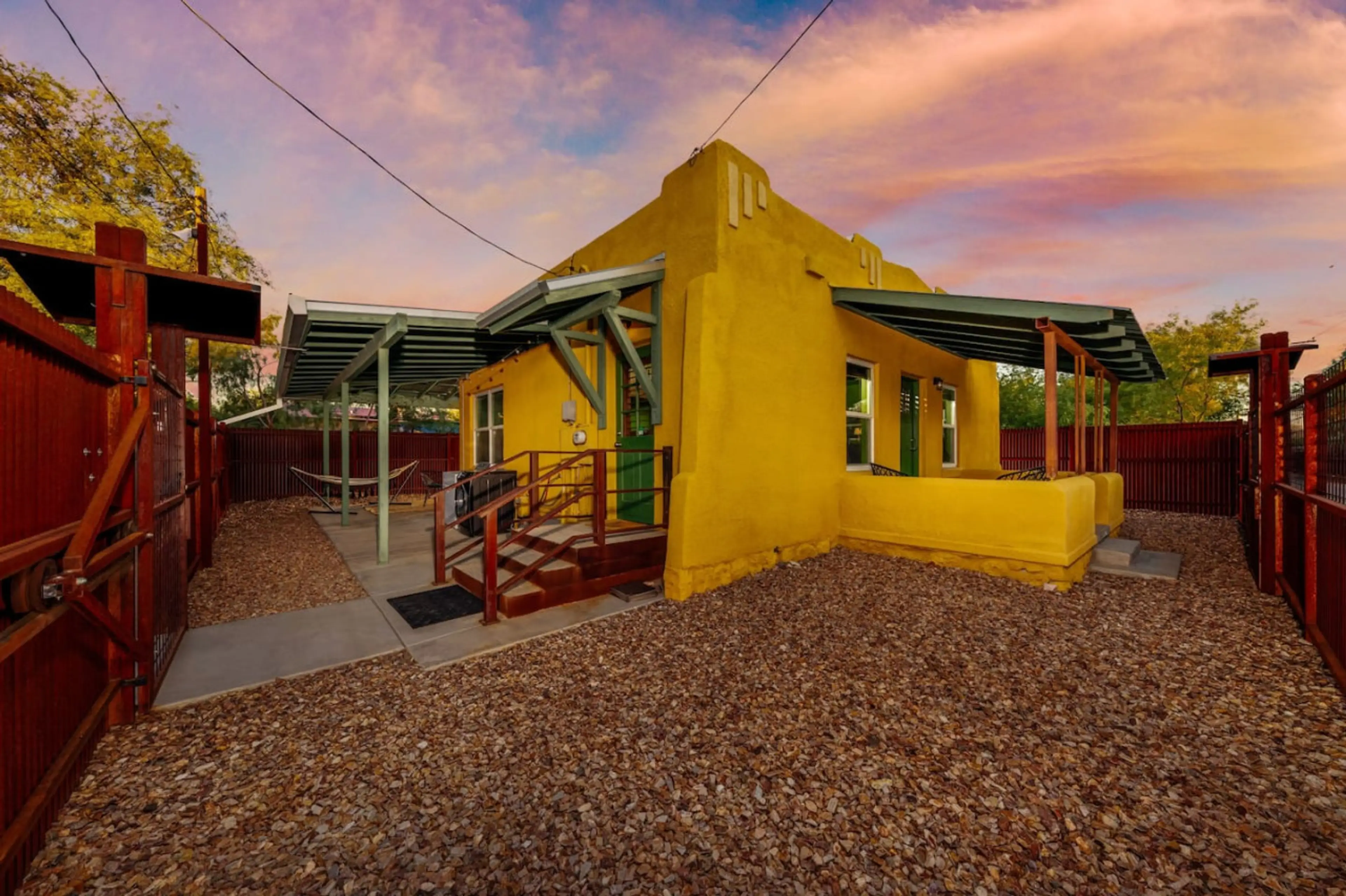 This fully fenced-in property has three stairs leading to the front entrance. A covered patio continues around two sides of the home, and there is an additional west-facing covered patio.