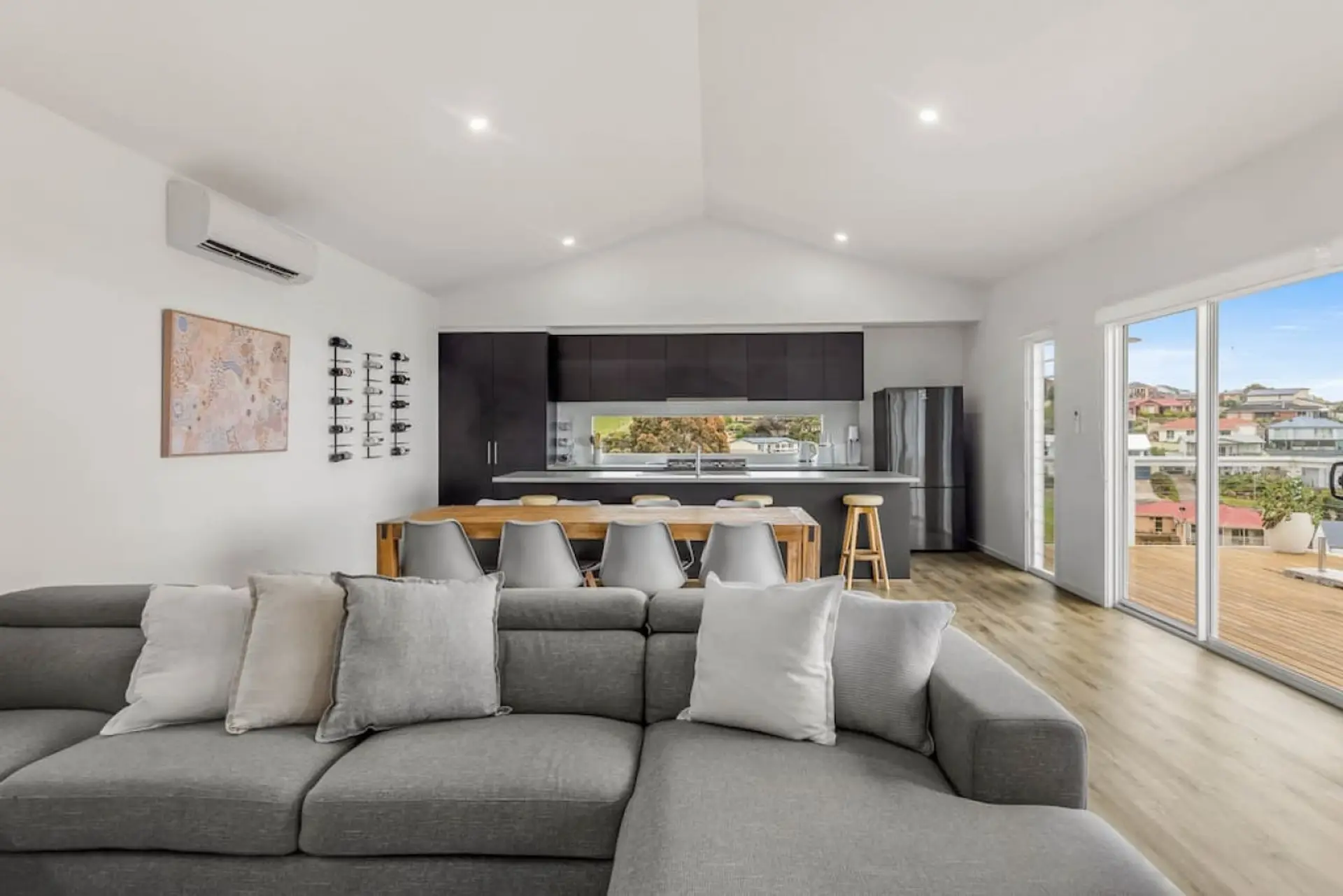 The living room's sleek gray and white theme creates a sophisticated and calming atmosphere, perfect for relaxation and socializing.