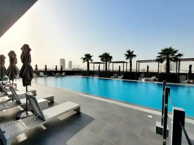 Sun loungers and parasols along the building's outdoor swimming pool