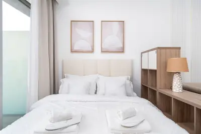 Neatly made bed with framed art above the upholstered headboard