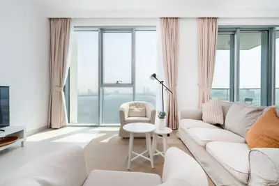 The living room seen from the sofa side, with TV and bright windows