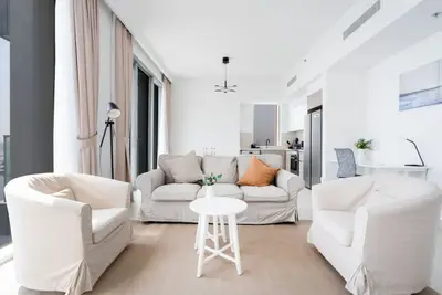 Comfortable lounge with sofa and two armchairs beside the open kitchen