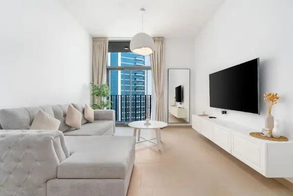 Grey corner sofa and long white media console in the sunlit living area