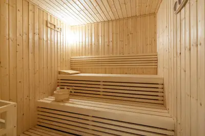 Wood-lined sauna with tiered bench seating and soft lighting