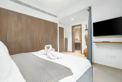 Another angle of the bedroom showing the wall TV and ensuite door
