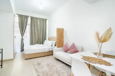 Bright studio pairing a double bed, loveseat and dining table for two