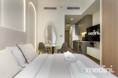 Studio overview from the bed side, showing dining area, kitchen and TV unit