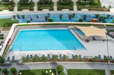 Bird's eye view of the shared pool deck with loungers and shade sail