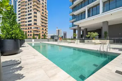 Rooftop pool flanked by residential towers and lush planters