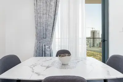 Dining table with marble-look top and city construction view