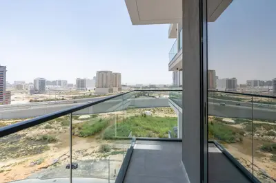 Glass-railed balcony overlooking an open desert and road horizon