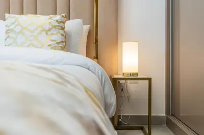 Close-up of the bedroom headboard with a warm bedside lamp