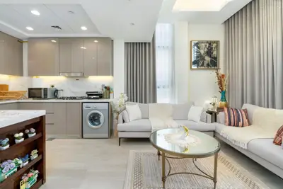 Open-plan living space with cream sofas and fitted beige kitchen