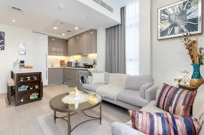 Another angle of the lounge, open kitchen visible behind the sofas