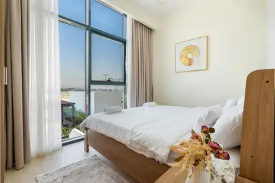 Bedroom with corner window, white linens and dried flower accents
