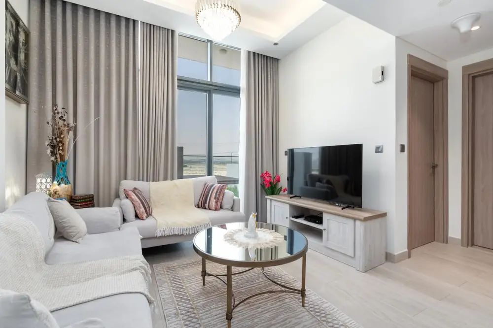 Living room with TV console, chandelier and soft grey curtains