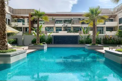 Palm-lined courtyard pool with a dark stone water feature