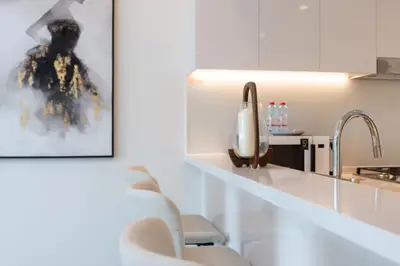 Breakfast bar detail with upholstered stools and sleek white counters