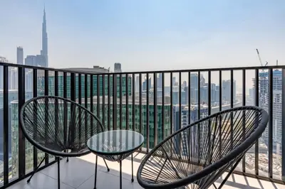 Balcony seating for two with Burj Khalifa rising over the skyline