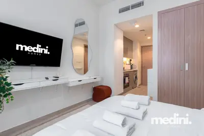 Media wall with floating console and sculptural mirror by the kitchenette