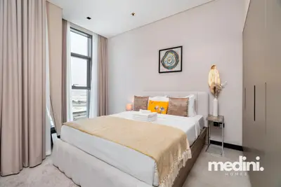 Bright sleeping area with a plush double bed beside a tall window