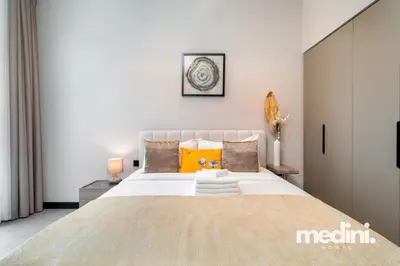 Front view of the double bed with layered cushions and bedside lamps