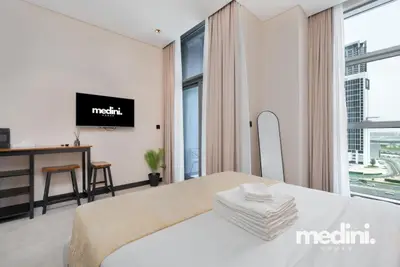 Studio corner with wall-mounted TV, work table and city-facing window