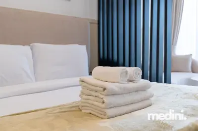 Fresh white towels stacked on the bed, ready for arrival