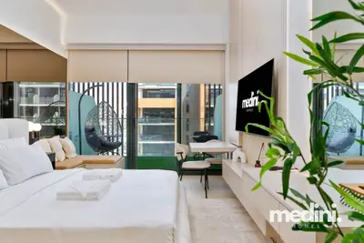 The bed facing floor-to-ceiling windows and the balcony egg chair