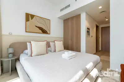 Comfortable double bed with fresh towels and framed artwork