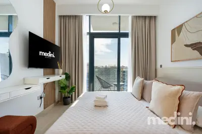 Bright sleeping space with wall TV and curtained balcony door
