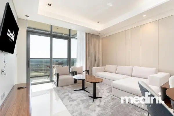 Bright living room with cream corner sofa, wall TV and balcony access