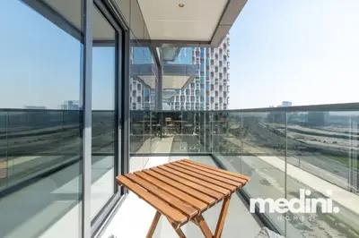 Compact balcony corner with wooden folding table and glass railing