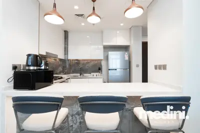 Breakfast bar with three stools under copper pendant lights